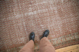 Distressed antique Malayer carpet detail showing faded repeating botehs and visible foundation wear.