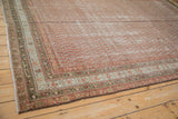 Faded ruby red botehs and dusty denim blue plant borders on distressed antique Malayer carpet.