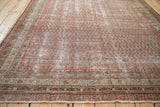 Antique Malayer carpet displaying multiple aged borders with meandering vine patterns and frayed sides.