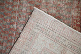 View of the antique Malayer rug's worn pile, visible foundation, and striped reverse weave.