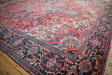 Vintage Ahar carpet corner: scrolled leaves, intricate vines, brick red, and sapphire blue palette.