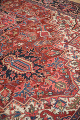 Vintage Ahar carpet detail: scrolled floral design with brick red, navy blue, and beige.