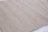 Modern beige herringbone pattern on a tightly woven handmade rug.