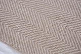 Handmade Dawn rug close-up, showing tonal beige geometric chevron pattern and woven texture.