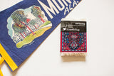 Persian Qashqai Carpet Coaster with vibrant red and blue geometric pattern, white fringe, in packaging.
