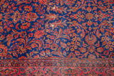 Curvilinear floral design in red and gold on the royal blue Kashan field and red border.