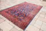 Intricately woven royal blue and red antique Kashan rug with visible white knots.