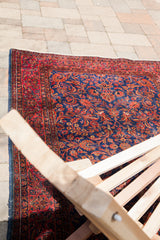 Intricate red floral motifs and white knots on a royal blue antique Persian Kashan rug.