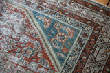 Distressed pile detail on vintage Malayer rug with faded teal, rust, and silver tones.
