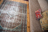 Distressed pattern on a vintage Malayer rug, with blanched silver, teal, and faded red.