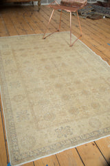 Textured gray border and soft gold interlaced palmettes on a vintage Sivas rug corner.