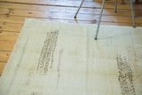 Distressed Oushak rug's corner with abstract patterns, worn texture, and short fringe.