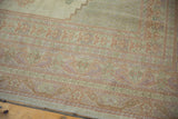 Delicate pastel peach and lavender border patterns on a vintage Oushak carpet corner.