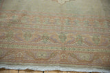 Fringe and curvilinear pastel motifs in peach, lavender, and sage green on a Vintage Oushak border.