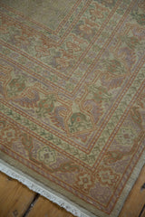 Vintage Oushak carpet corner featuring delicate pastel green, orange, lavender border, and fringe.