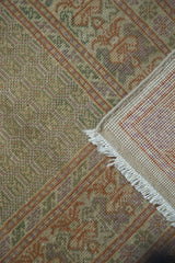Hand-knotted pile, woven back, and fringe of a vintage Turkish carpet, soft pastel tones.