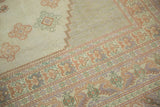 Stylized motifs and pastel tones in the border of this vintage Oushak rug.