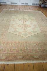 Soft fringe and delicate pastel bird motifs on the vintage Oushak carpet border.