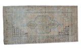 Distressed Oushak rug with soft-tone beige, ivory, and slate blue, featuring a faded medallion.