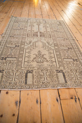 Blanched beige and dark brown geometric Oushak rug corner with subtle light blue accents.