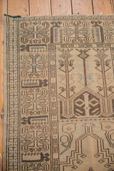 Oushak rug corner with blanched geometric pattern in silver, charcoal, and faded blue.