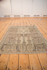 Geometric pattern detail from a vintage blanched Oushak rug in grey, charcoal, and light blue.