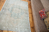 Blanched traditional Oushak rug with soft ivory pile and faded powder blue patterns.