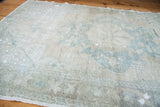 Blanched texture and faded floral motifs in ivory and powder blue on the Oushak rug.