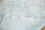 Folded Vintage Oushak rug showcasing light ivory and powder blue pile and woven foundation.