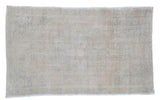 Vintage Turkish distressed Oushak rug in blanched beige with soft pink floral motifs.
