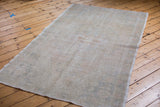Close-up of the distressed, blanched edge and faded texture on the vintage Oushak rug.