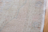 Close-up of the hand-knotted foundation and selvedge on a vintage Oushak rug, beige tones.