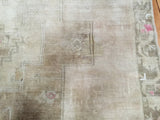 High sheen pile detail showcasing muted beige and soft bronze geometric patterns.
