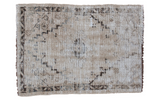 Vintage distressed Turkish Oushak rug with muted beige and brown geometric patterns.