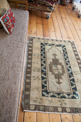 Geometric central motif, dark patterned border, and light fringe on the vintage Oushak rug.
