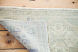 Vintage Oushak runner's fold revealing hand-knotted weave, soft abrash, and geometric pattern.