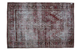 Distressed vintage Persian Joshegan rug, dramatic dark red and faded blue, threadbare texture.