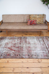 Dramatic dark red and threadbare light tones create a distressed texture on this vintage Joshegan rug.