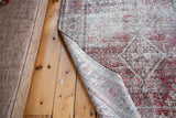 Distressed vintage Persian Joshegan rug showing threadbare texture and woven backing.