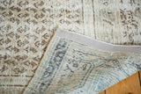 Textured distressed ivory pile of vintage Persian rug with folded back view.