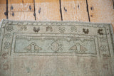 Geometric border of a Vintage Oushak rug in sea foam green and blanched silver.
