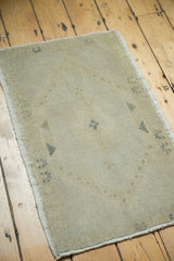 Textured blanched beige Oushak rug pile with subtle charcoal geometric motifs at the corner.