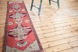 Ruby red medallion with silver spandrels on a cranberry vintage Oushak runner.