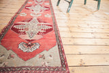 Oushak runner displaying a ruby red medallion with cranberry field and silver spandrels.