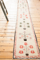 Vintage Oushak runner with whimsical tree of life motifs and geometric blossoms on ivory.