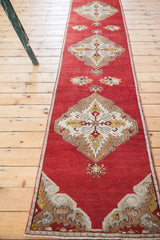 Cherry red vintage Oushak runner with a bronze, ivory, and saffron yellow medallion.