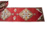 Cherry red Vintage Oushak runner, partially unrolled, showing bronze and saffron medallions.