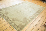 Vintage Oushak rug with subtle earth tone grey field and delineated charcoal-brown border.