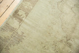Soft pile texture and subtle delineation of earth-toned patterns on a vintage Oushak rug.