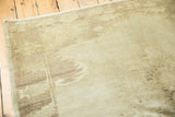 Vintage Oushak rug corner detail with subtle grey, earth tone variations, and fringed edge.